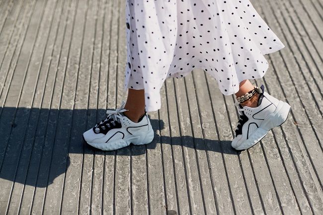 Zapatillas blancas combinadas con vestido de lunares, en el 'street style' de Copenhague