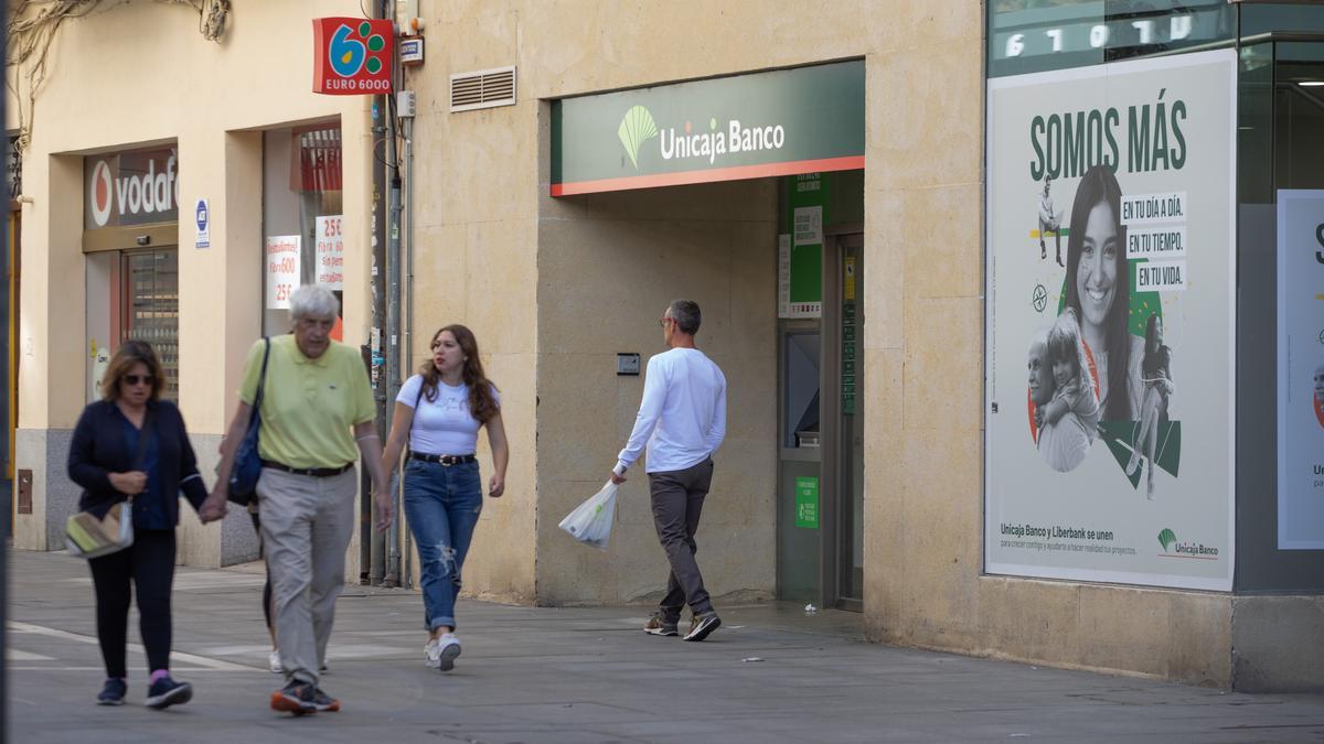 Zamoranos paseando cerca de la central de Unicaja Banco en Zamora.