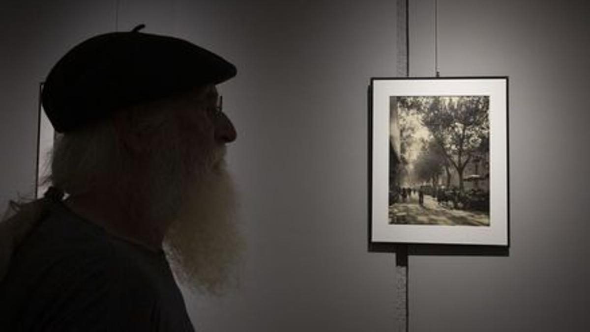 Un aficionado a la fotografía, ante la imagen retratada y revelada por Català-Roca de la Rambla de Barcelona.