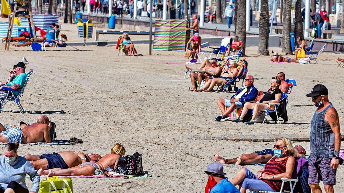 Un grupo de turistas en la playa de Levante de Benidorm este febrero. | DAVID REVENGA