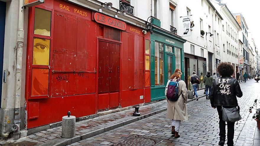 Dues dones passen per davant de negocis tancats a París.