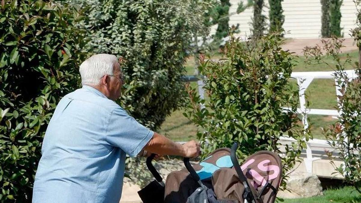 Un abuelo pasea junto a sus dos nietos.