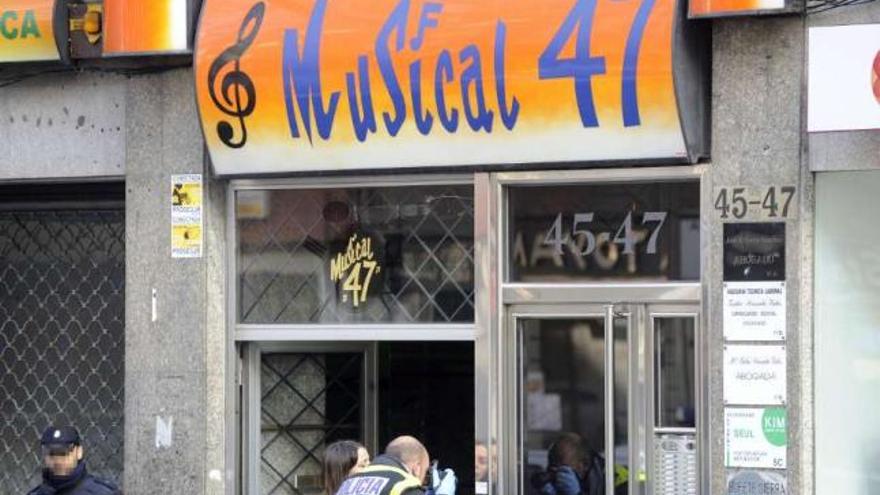 Miembros de la Policía Científica, ayer, en la entrada de la tienda. / carlos pardellas