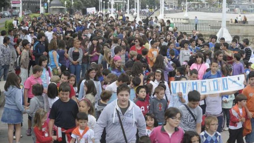 Imaxes da marcha Correlingua, na que máis de 3.000 escolares de centros educativos da comarca percorreron a distancia que separa o estadio de Riazor da Torre de Hércules. / víctor echave / fran martínez