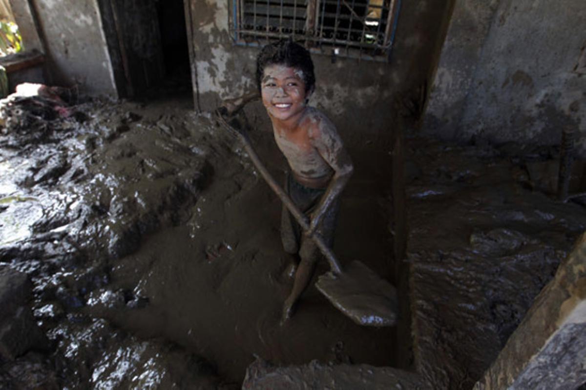Richard Ragcadvo, un nen filipí de 9 anys, retira amb una pala el fang acumulat a l’entrada de casa seva, a Iligan City, al sud de Mindanao (Filipines).