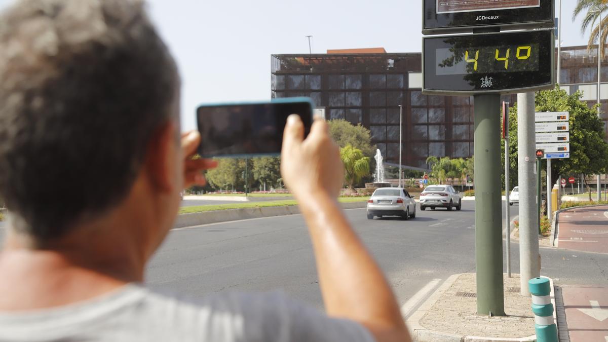 Un hombre fotografía un termómetro que marca los 44 grados