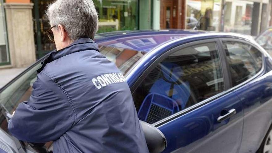 Un controlador de la ORA pone un aviso a un coche.