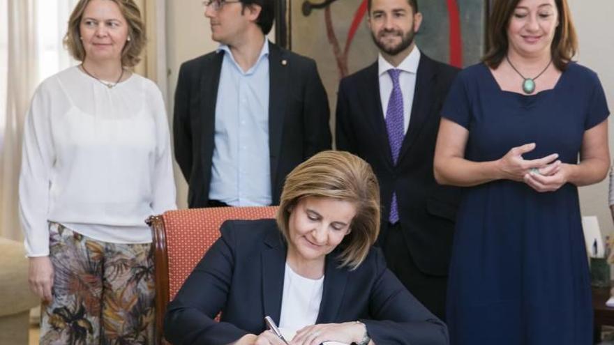 Armengol mira cómo Báñez firma el pacto de colaboración.