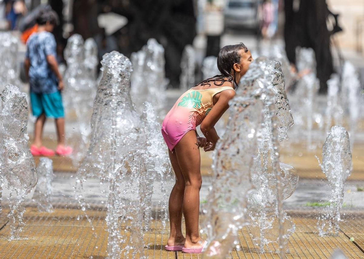 Una niña se refresca en una fuente pública este miércoles en Alicante