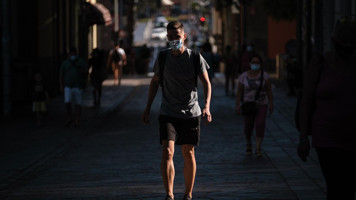 Un chico con mascarilla durante una jornada de calor en la capital tinerfeña.