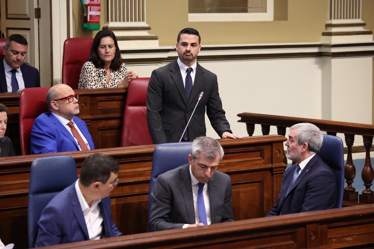 El presidente Fernando Clavijo (d), sentado en su escaño, escucha la intervención del nacionalista David Toledo.