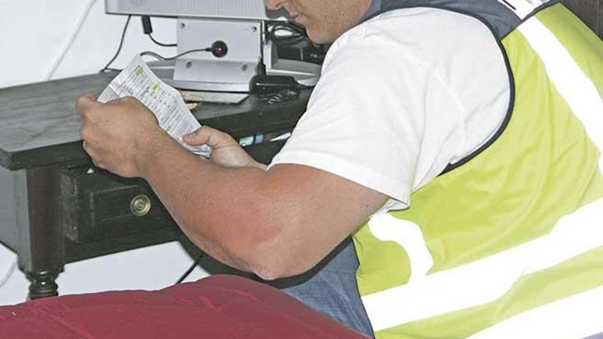 Un agente de la Brigada de Extranjería examina documentación.