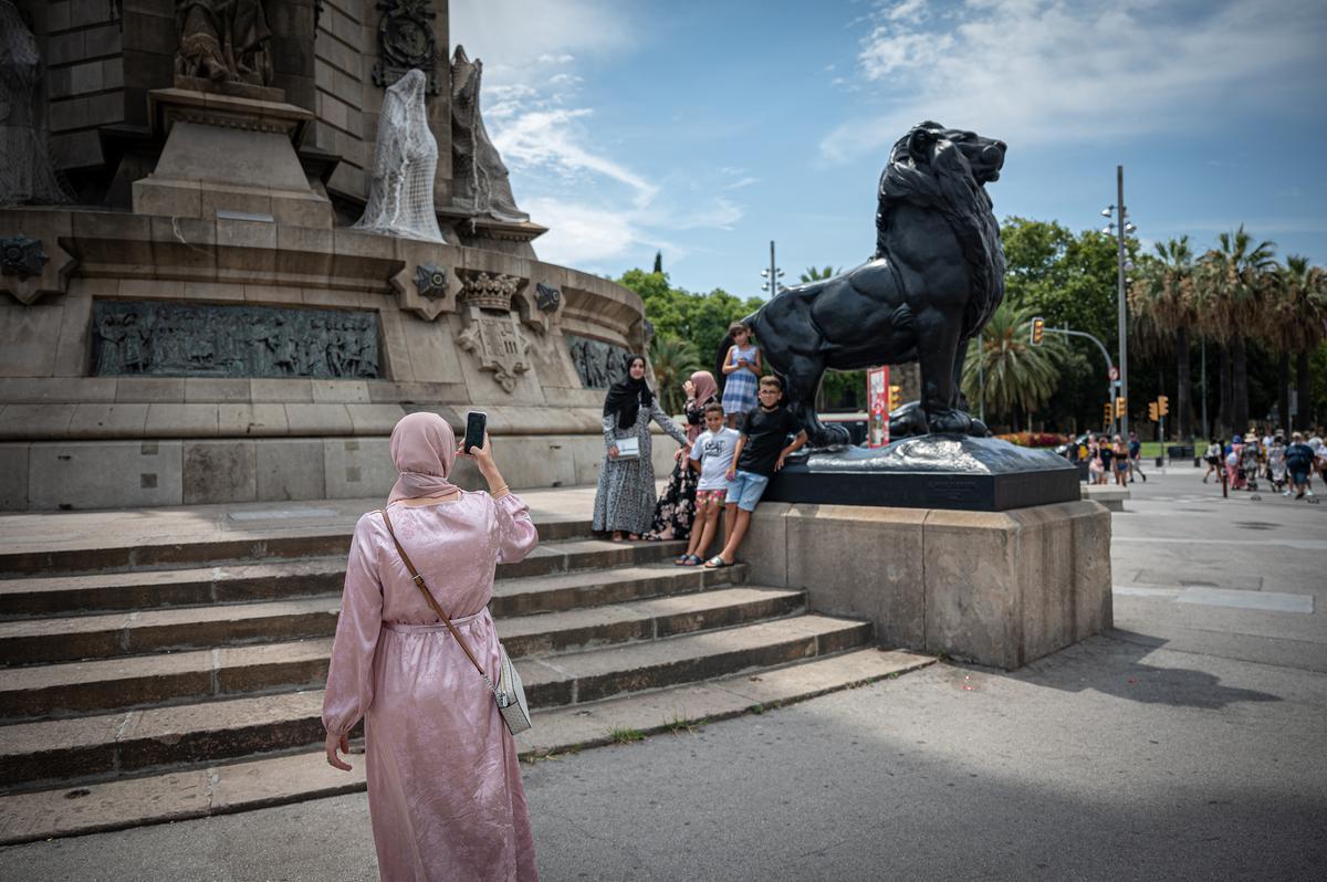 Turistas junto a uno de los leones de Colón.
