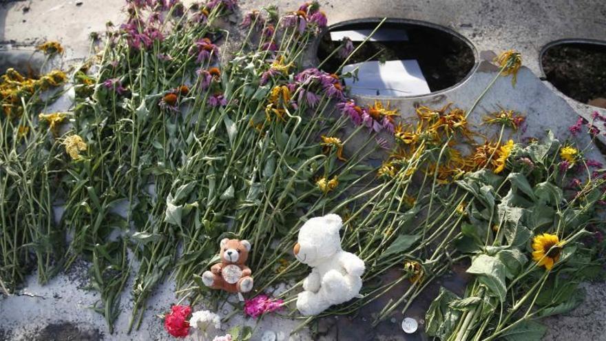 Flores y peluches sobre los restos del avión.