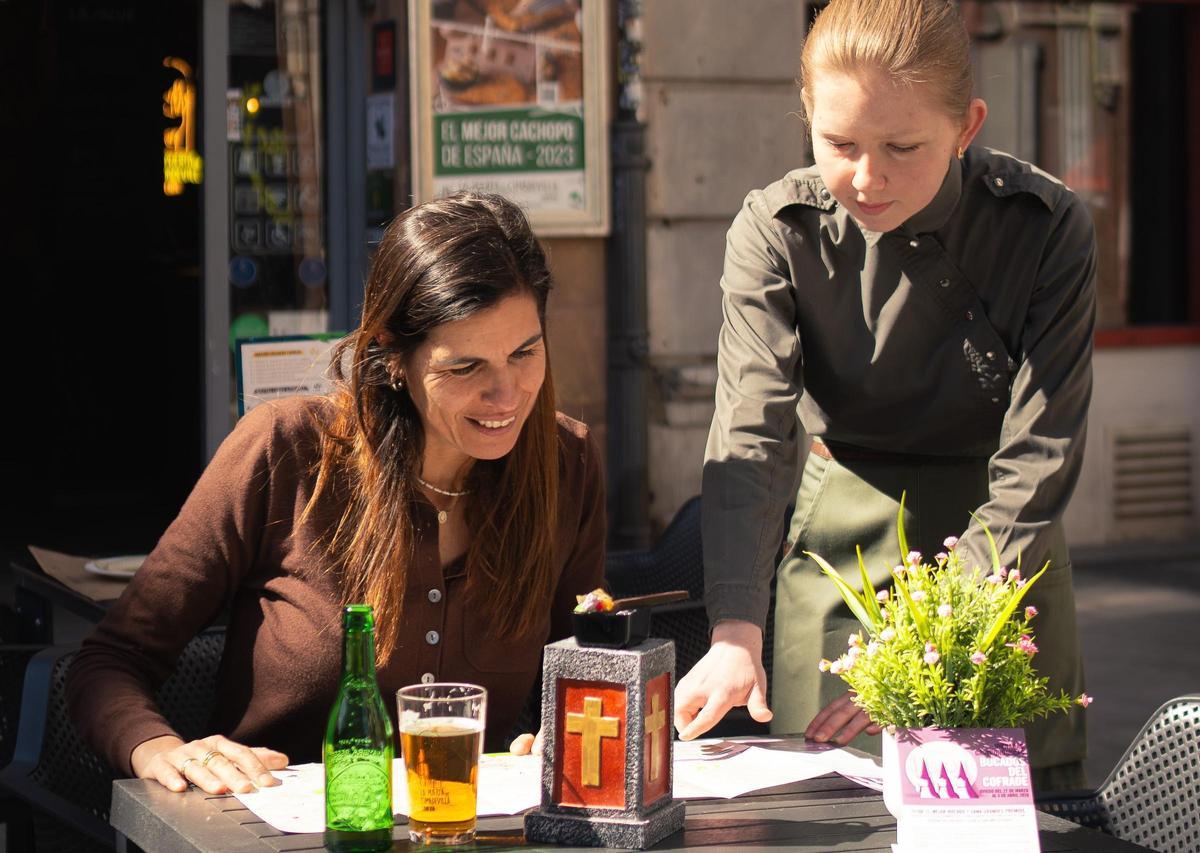 Bikezzina Anastasiia sirve a Beatriz Alonso una cuchara de chocolate comestible con atún rojo, cabrales, kimchi, alioli verde y atún en La Puerta de Cimadevilla.