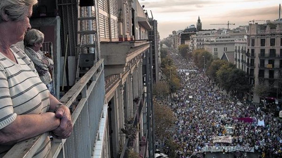 Unas vecinas observan el desarrollo de la manifestación desde un balcón de su domicilio en la calle de Aragó de Barcelona.