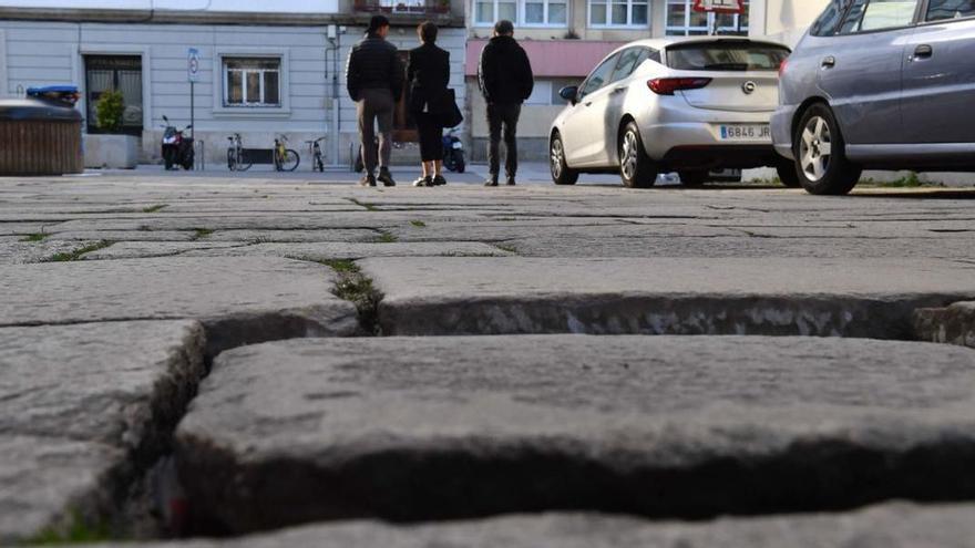 Huecos entre baldosas y desniveles y vegetación en las juntas de la calle Herrerías.   | // VÍCTOR ECHAVE