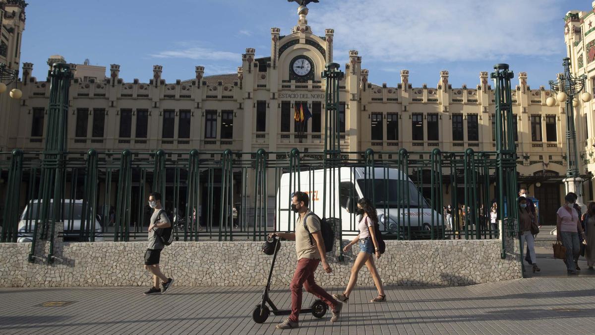 Un usuario de patinete camina frente a la Estación del Norte de València, en una imagen de archivo.