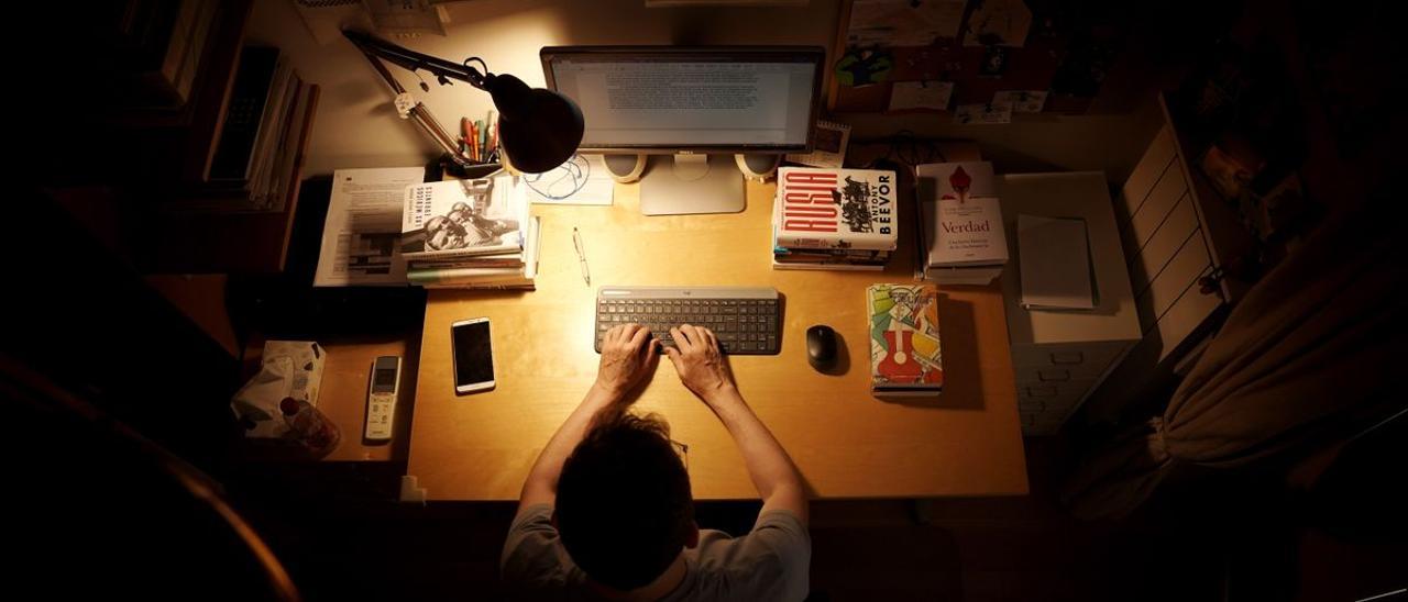 Un escritor en una habitación de su casa.