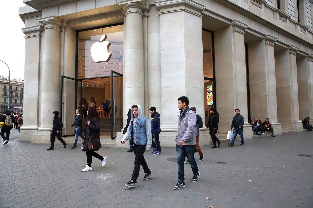 Gente paseando por delante de la tienda Apple de Barcelona.