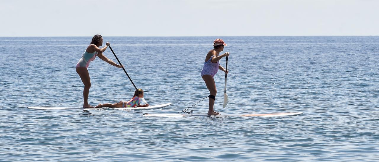 Rosi delante y Laura detrás, practican paddle surf en la Playa del Águila.