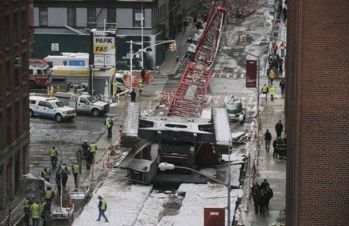 Emergency responders respond to the scene of the 565-foot-tall crane that toppled and flipped upside down stretching along nearly two city blocks in downtown Manhattan in New York