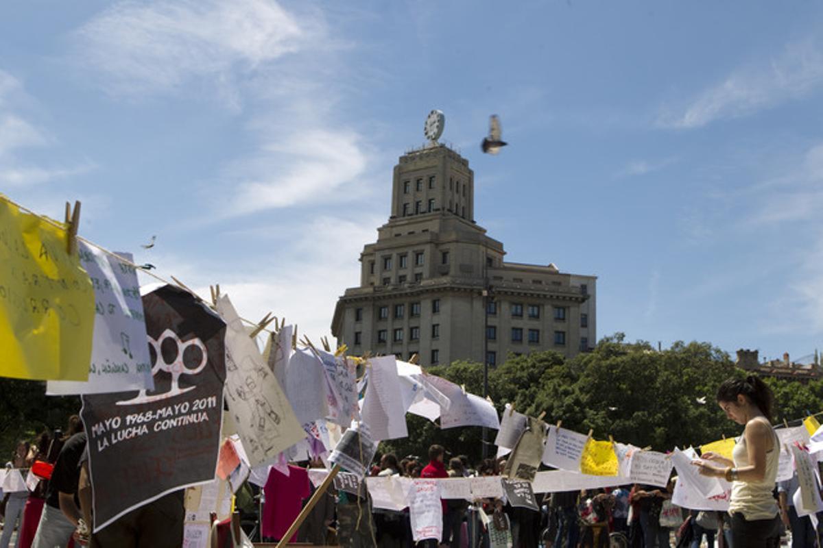Una participant en la protesta, al costat de papers amb les reivindicacions dels indignats. Una participant en la protesta, al costat de papers amb les reivindicacions dels indignats.