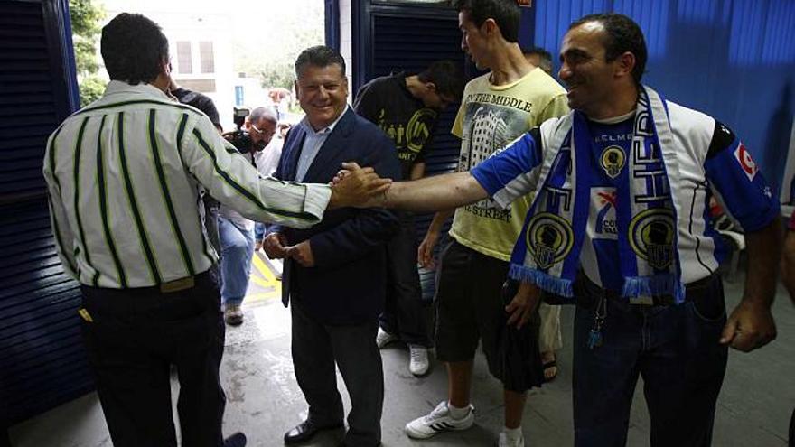 Enrique Ortiz y Valentín Botella saludan ayer a varios aficionados en las oficinas del club.