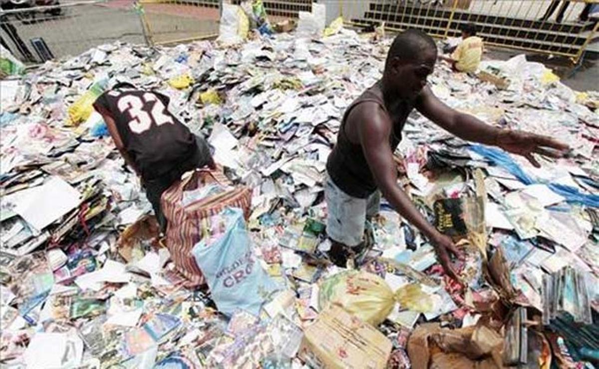 Un empleat de l’alcaldia de Manila (Filipines) participa en la destrucció de milers de cedés pirates després d’una operació d’incautació.