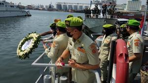 Oficiales de la marina indonesia lanzan coronas de flores al mar en homenaje a los tripulantes del submarino naufragado.