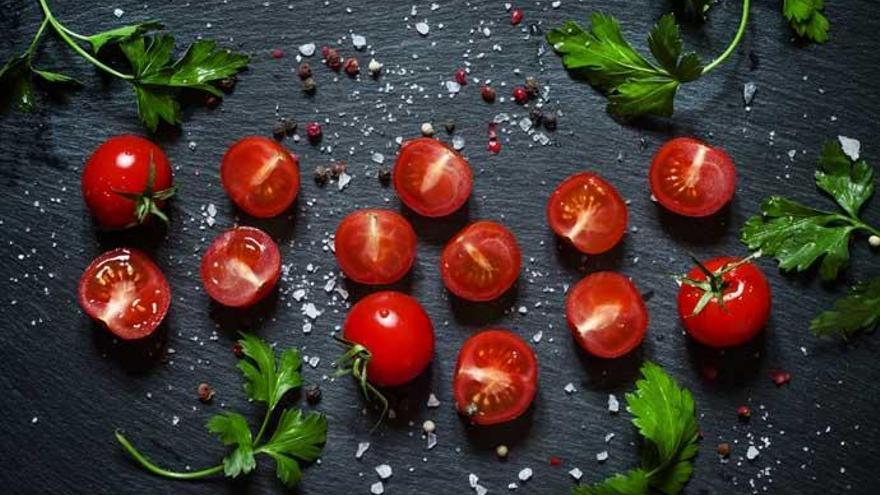 Tomates cherry, sobre una tabla de cortar.