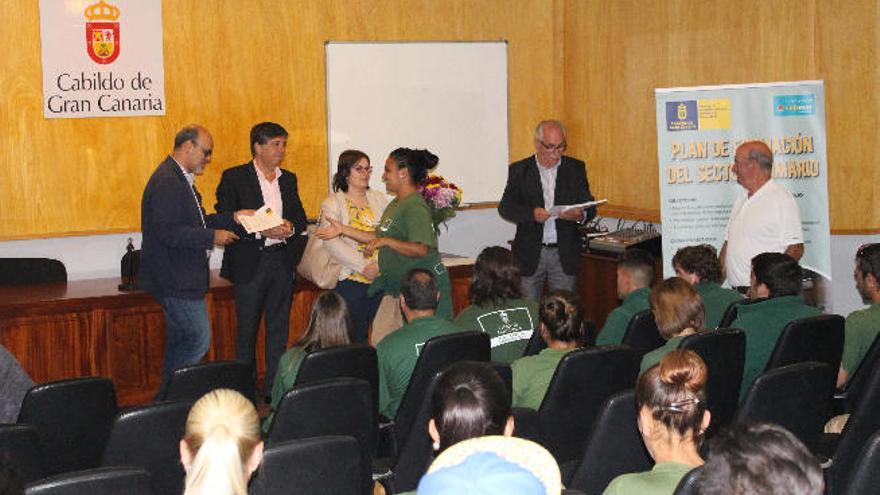 Una joven recibe su diploma en el acto del Cabildo.