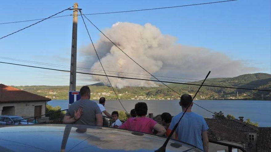 Vecinos observando el avance del incendio, ayer por la tarde.