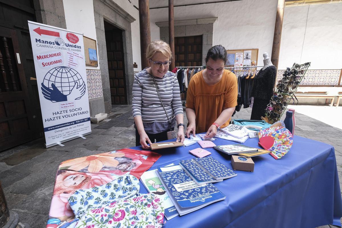 Dos voluntarias de Manos Unidas preparan una de las mesas.