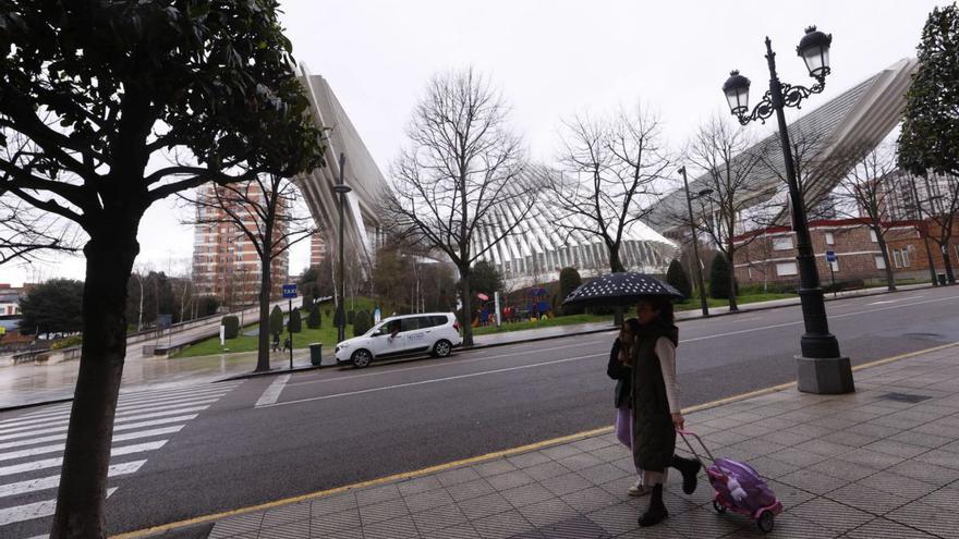 Una mujer y una niña pasan por delante del Palacio de Congresos de Oviedo, que en 2026 albergará un centro educativo de Ciencias de la Salud de la Universidad Alfonso X el Sabio. | LUISMA MURIAS