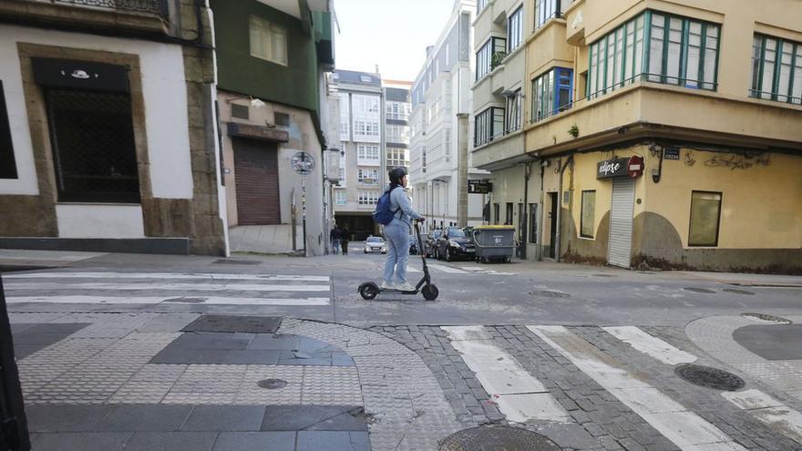 Una usuaria de patinete eléctrico circula por la calle Orzán.   | // IAGO LÓPEZ