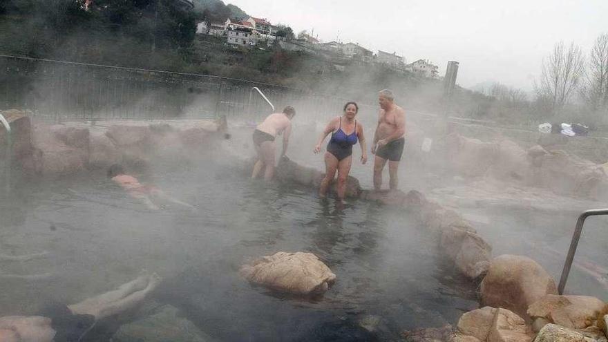 Bañistas, ayer, en A Chavasqueira (Ourense): en el exterior, en torno a 1º C; en el agua, a 43º.  // Iñaki Osorio