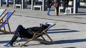 Barcelona. 11.01.2019. Barcelona Un hombre toma el sol con el abrigo preciso en la plaza de Glories con motivo del descenso de las temperaturas a causa de la ola de frío. Fotografía de Jordi Cotrina