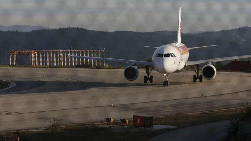 Una avión de Iberia circula cerca de uno de los entramados de antenas del ILS de Peinador. // R. Grobas