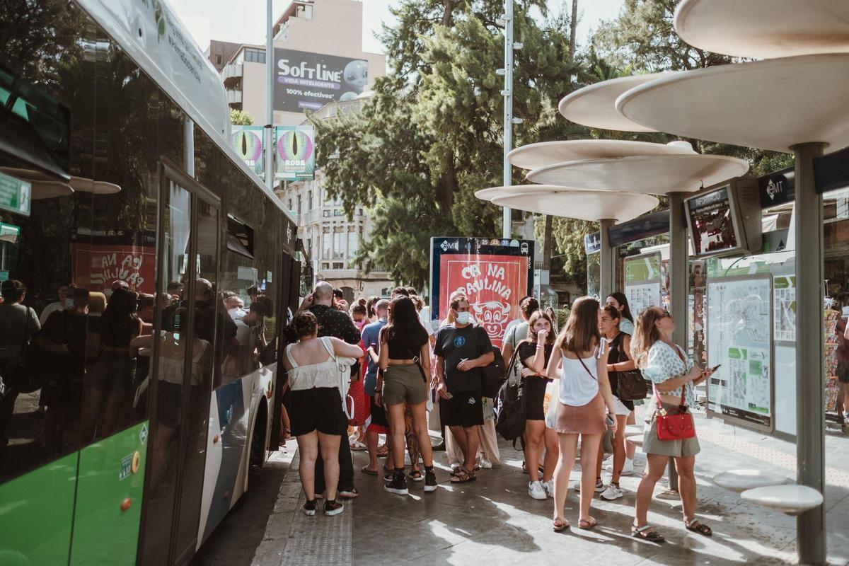 Pasajeros esperan para entrar en un bus de la EMT.