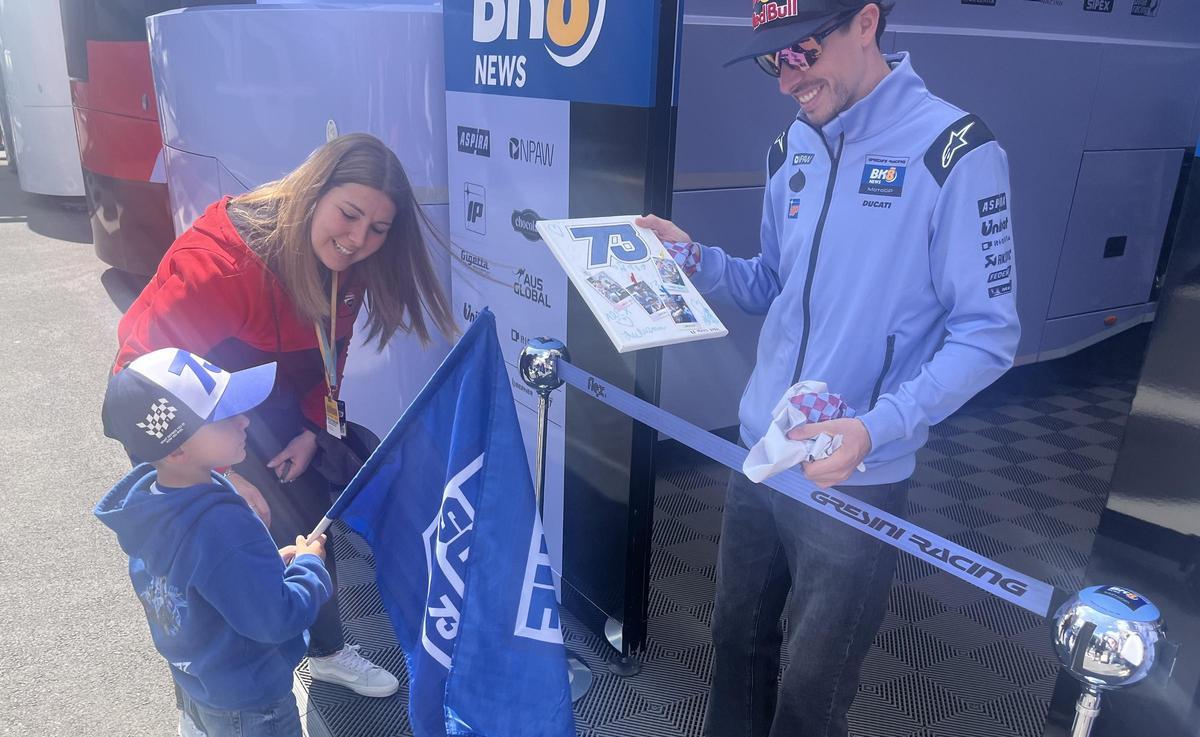 Àlex Márquez, ayer, recibiendo un regalo de uno de sus fans más pequeños, en Le Mans.