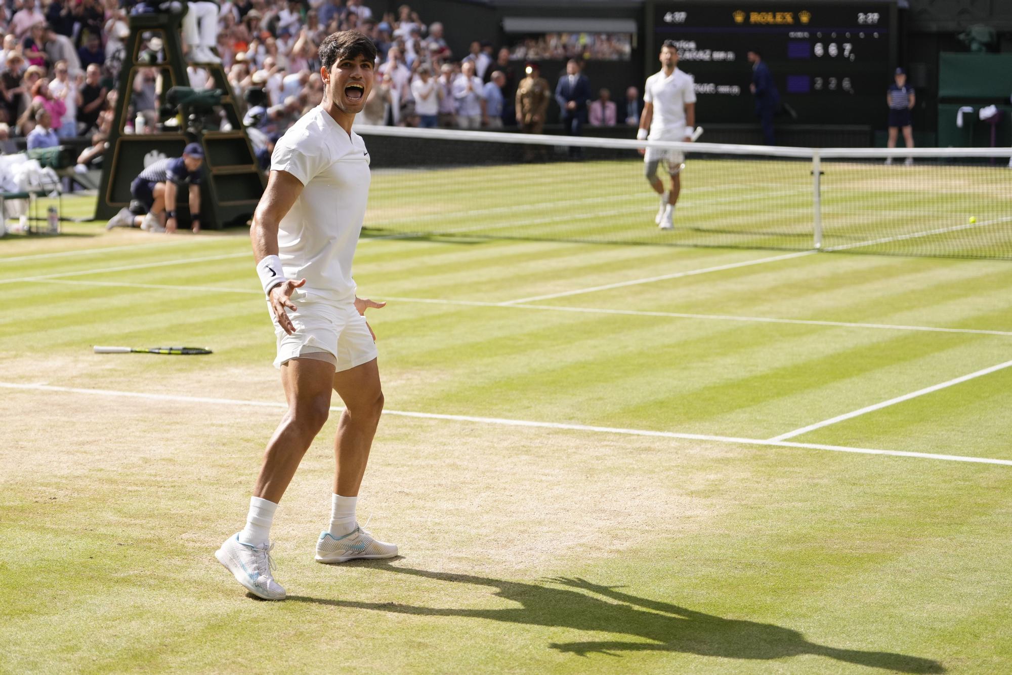 Carlos Alcaraz of Spain celebrates after defeating Novak Djokovic of Serbia in the men's singles final at the Wimbledon tennis championships in London, Sunday, July 14, 2024. (AP Photo/Alberto Pezzali)