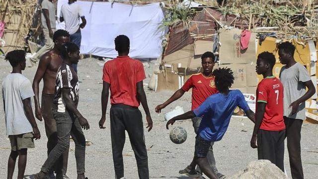 Un grup de joves juguen a futbol a la platja del Trampolín, ahir. | REDUAN / EFE
