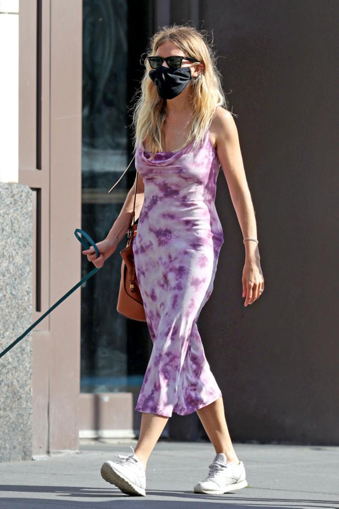 Sienna Miller sabe que este cómodo vestido de invitada queda ideal con sandalias de tacón y zapatillas blancas para llevar a diario