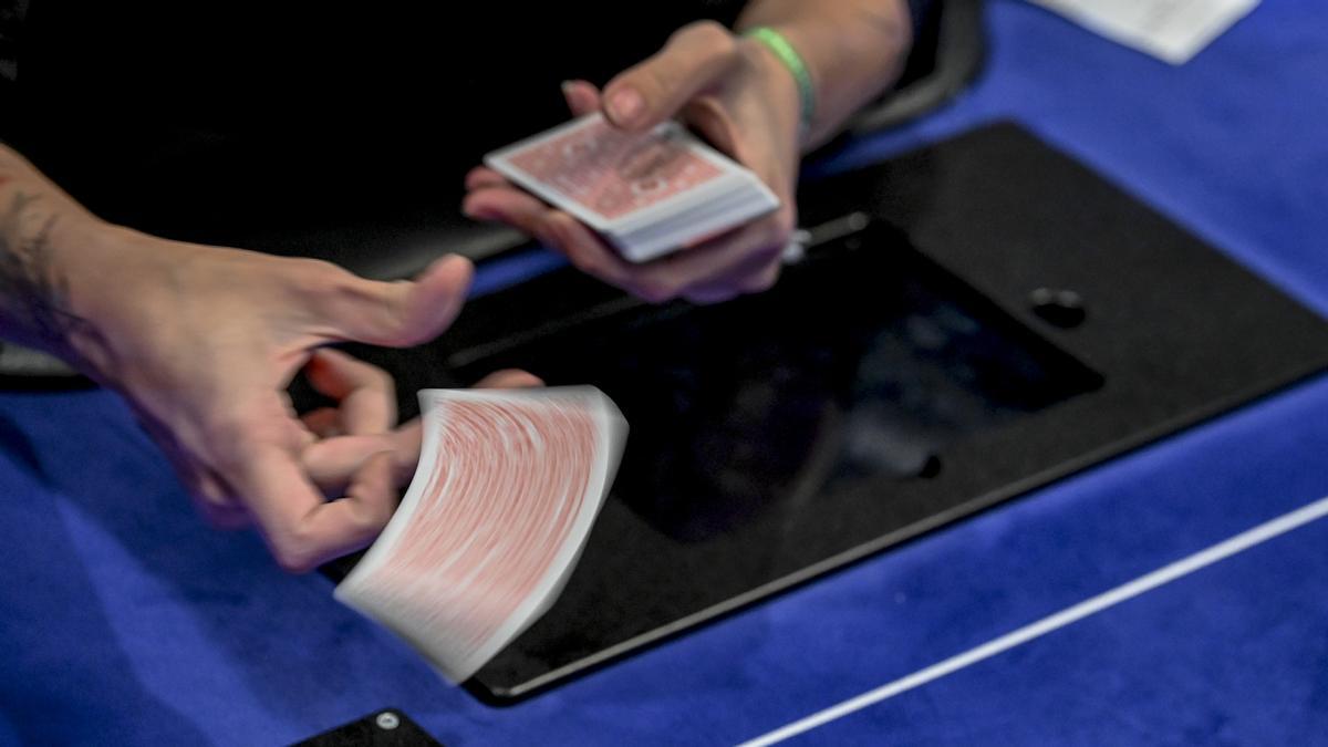 La rápida mano de una croupier reparte las cartas en una mesa del Casino de Barcelona.