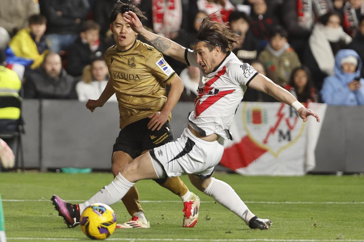 MADRID, 16/03/2025.- El defensa uruguayo del Rayo Vallecano, Alfonso Espino (d), disputa el balón ante el centrocampista japonés de la Real Sociedad, Takefusa Kubo, durante el encuentro correspondiente a la jornada 28 de Laliga EA Sports que disputan hoy domingo Rayo y Real Sociedad en el estadio de Vallecas, en Madrid. EFE / Sergio Perez.