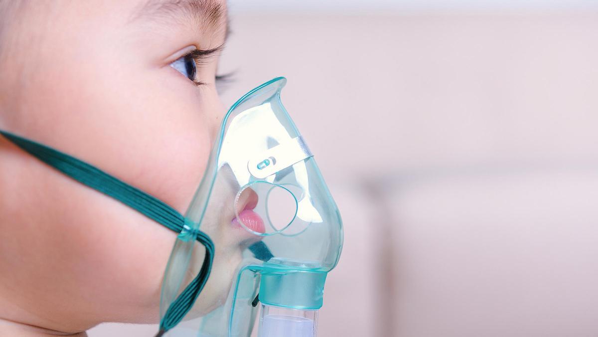 Un nen de 2 anys utilitza un inhalador per alleujar una malaltia respiratòria.