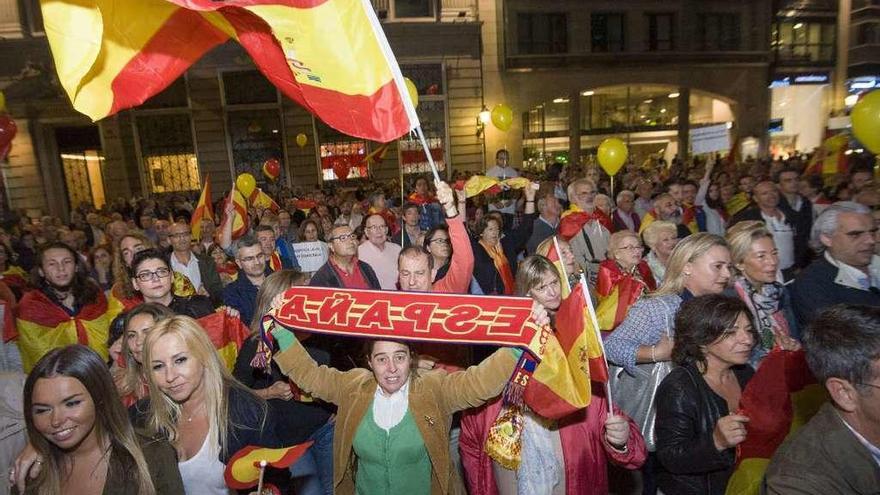 Asistentes a la concentración en el Obelisco, entre ellos ediles del PP, con banderas de España.