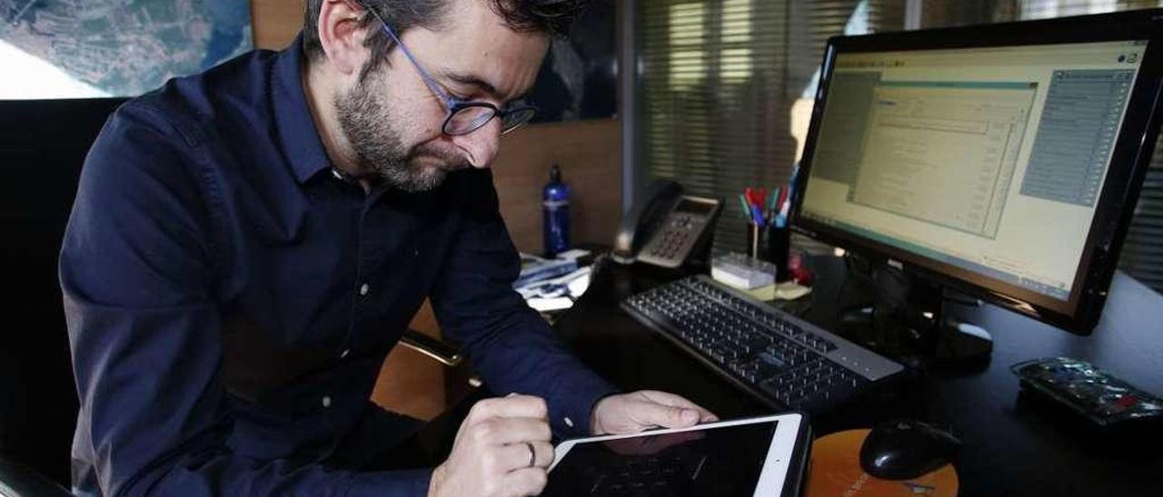 Manuel Campa firma un expediente municipal en su tableta.