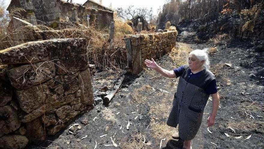 Dolores muestra los daños causados por el fuego en su finca. // G.S.